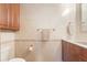 Bathroom with beige tile, wood cabinets, and ample towel storage at 1930 Bayshore Dr, Englewood, FL 34223