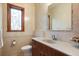 Well-lit bathroom featuring a vanity with ample counter space, a toilet, and a decorative window at 1930 Bayshore Dr, Englewood, FL 34223
