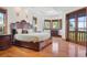 Luxurious bedroom with hardwood floors, a large bed, and bay windows overlooking the water at 1930 Bayshore Dr, Englewood, FL 34223
