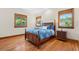 Bedroom with hardwood floors, neutral paint, and two windows with wood trim at 1930 Bayshore Dr, Englewood, FL 34223