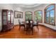 Charming dining area with wood floors, a round table, and natural light from large windows at 1930 Bayshore Dr, Englewood, FL 34223