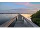 Scenic view of a wooden dock extending into a tranquil body of water at sunset at 1930 Bayshore Dr, Englewood, FL 34223