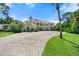 Luxury home showcasing lush landscaping, circular driveway, and elegant architecture at 1930 Bayshore Dr, Englewood, FL 34223