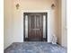 Elegant front door with decorative glass sidelights and beautiful stone flooring at 1930 Bayshore Dr, Englewood, FL 34223