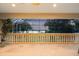 Screened patio with travertine floors overlooking lush trees and water at 1930 Bayshore Dr, Englewood, FL 34223
