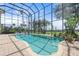 Screened-in pool with brick surround and view of lawn extending to the water at 1930 Bayshore Dr, Englewood, FL 34223
