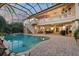 Outdoor swimming pool enclosed in screened porch connected to main house with outdoor stairwell to balcony at 1930 Bayshore Dr, Englewood, FL 34223