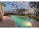 Home's screened-in pool with brick surround and water view at 1930 Bayshore Dr, Englewood, FL 34223