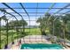 Screened-in pool with a view of lush landscaping and the bay at 1930 Bayshore Dr, Englewood, FL 34223