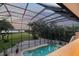 A screened-in pool and patio with a view of the manicured lawn and bay at 1930 Bayshore Dr, Englewood, FL 34223