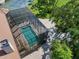 Aerial view of the screened pool and lanai area, surrounded by lush trees at 1930 Bayshore Dr, Englewood, FL 34223