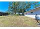 Spacious backyard with a screened-in porch, mature trees, and a manicured lawn at 2402 Scenic Dr, Venice, FL 34293