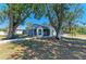 Backyard view of the home with a screened-in porch, mature shade trees, and a fenced yard at 2402 Scenic Dr, Venice, FL 34293