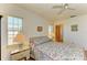 Cozy bedroom with floral bedding, side tables with lamps, and a ceiling fan for added comfort at 2402 Scenic Dr, Venice, FL 34293