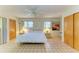 Bright bedroom with tiled floors, ceiling fan, and ample natural light from two windows at 2402 Scenic Dr, Venice, FL 34293
