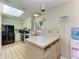Bright kitchen with white cabinets, modern appliances, tile floors, a water cooler, and a sun-filled window at 2402 Scenic Dr, Venice, FL 34293