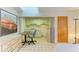 Bright kitchenette with white cabinets, tile flooring, and a skylight for natural lighting at 2402 Scenic Dr, Venice, FL 34293
