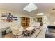 Bright living room featuring skylight, modern furniture, and an open floor plan to the dining area and kitchen at 2402 Scenic Dr, Venice, FL 34293