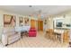 A large living space featuring tile flooring, a ceiling fan, cozy furniture, and easy access to the kitchen at 2402 Scenic Dr, Venice, FL 34293