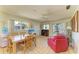 Bright living space with tile floors, many windows, a dining table, a work desk, and comfortable furniture at 2402 Scenic Dr, Venice, FL 34293
