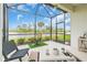 Enclosed lanai with waterfront views, featuring a screened-in enclosure, neutral color scheme, and decorative accents at 253 Tracino Ter, Nokomis, FL 34275