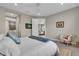 Comfortable main bedroom featuring tiled floor, a cozy chair, and a glimpse into the Primary bath at 253 Tracino Ter, Nokomis, FL 34275