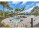 Community pool featuring ample seating, swaying palm trees, a hot tub, and a beautiful clubhouse at 253 Tracino Ter, Nokomis, FL 34275