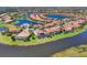Aerial view of homes with red tiled roofs, private pools, manicured lawns and waterfront views at 261 Portofino Dr, North Venice, FL 34275