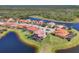 Aerial view of properties with red tiled roofs, manicured lawns, with lake and nature preserve views at 261 Portofino Dr, North Venice, FL 34275