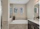 Relaxing bathroom featuring a soaking tub and tiled walls at 261 Portofino Dr, North Venice, FL 34275