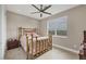 Well-lit bedroom with a decorative gold metal bed frame, tile floors, and a window with scenic outdoor views at 261 Portofino Dr, North Venice, FL 34275