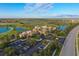 Aerial view of the clubhouse nestled within a beautiful golf course community with lakes and manicured landscaping at 261 Portofino Dr, North Venice, FL 34275