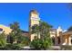 View of the clubhouse featuring a clock tower, manicured landscaping, and brick-paved walkway at 261 Portofino Dr, North Venice, FL 34275