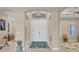 Bright foyer with arched doorway, double doors, tiled floors, modern light fixture, and colorful area rug at 261 Portofino Dr, North Venice, FL 34275