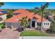 Beautiful single-Gathering home featuring lush landscaping, a brick driveway, and a classic tile roof at 261 Portofino Dr, North Venice, FL 34275