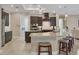 Modern kitchen with dark wood cabinetry, granite countertops, stainless steel appliances, and island seating at 261 Portofino Dr, North Venice, FL 34275