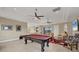 Spacious living room with pool table, comfortable seating, and natural light, perfect for entertaining guests at 261 Portofino Dr, North Venice, FL 34275