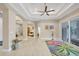 Spacious living room with decorative tray ceiling, large windows, and neutral walls at 261 Portofino Dr, North Venice, FL 34275