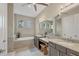 Beautiful bathroom featuring double vanity, granite countertops, soaking tub, and decorative lighting at 261 Portofino Dr, North Venice, FL 34275