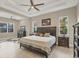 Spacious main bedroom featuring a tray ceiling, ceiling fan, tile floors, and ensuite bath at 261 Portofino Dr, North Venice, FL 34275