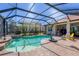 Relaxing screened pool with a brick patio, waterfall feature, and comfortable outdoor seating, perfect for enjoying sunny days at 261 Portofino Dr, North Venice, FL 34275