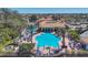 Aerial view of a vibrant community pool with clear blue water, surrounded by seating and beautiful landscaping at 261 Portofino Dr, North Venice, FL 34275
