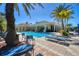 Community pool with clear blue water, lounge chairs, and palm trees, perfect for relaxation and recreation at 261 Portofino Dr, North Venice, FL 34275