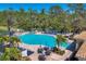 Aerial view of community pool surrounded by lush greenery, lounge chairs, and seating areas at 261 Portofino Dr, North Venice, FL 34275
