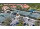 Aerial view of tennis courts with covered seating, adjacent to the community parking area at 261 Portofino Dr, North Venice, FL 34275