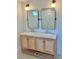 Bright bathroom featuring a wooden vanity with double sinks, a marble countertop and brass framed mirrors at 2904 N Ola Ave, Tampa, FL 33602
