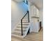 Bright staircase with modern black handrail and white risers complemented by wood grain floor and beverage center at 2904 N Ola Ave, Tampa, FL 33602