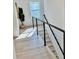 Upstairs hallway with bright window and view of staircase with modern black handrail and white risers at 2904 N Ola Ave, Tampa, FL 33602