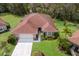 Aerial view of a well-maintained property with manicured lawn, landscaping, and mature trees at 3408 Brookridge Ln, Parrish, FL 34219
