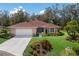 Beautifully landscaped home featuring manicured lawn and garden beds showcasing vibrant colors around the property at 3408 Brookridge Ln, Parrish, FL 34219